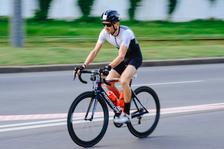 KHARKIV, UKRAINE - August 2, 2020: Triathon biking cyclist triathlete riding racing bike during ironman competition. Road cycling athlete in tri suit and helmet. Public events are allowed. Europe sport during CV pandemic.のeditorial素材