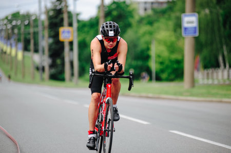 KHARKIV, UKRAINE - August 2, 2020: Triathon biking cyclist triathlete riding racing bike during ironman competition. Road cycling athlete in tri suit and helmet. Public events are allowed. Europe sport during CV pandemic.のeditorial素材