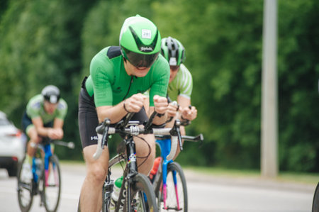 KHARKIV, UKRAINE - August 2, 2020: Triathon biking cyclist triathlete riding racing bike during ironman competition. Road cycling athlete in tri suit and helmet. Public events are allowed. Europe sport during CV pandemic.のeditorial素材