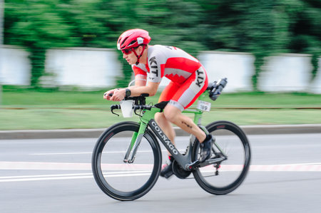 KHARKIV, UKRAINE - August 2, 2020: Triathon biking cyclist triathlete riding racing bike during ironman competition. Road cycling athlete in tri suit and helmet. Public events are allowed. Europe sport during CV pandemic.のeditorial素材