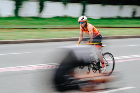 KHARKIV, UKRAINE - August 2, 2020: Triathon biking cyclist triathlete riding racing bike during ironman competition. Road cycling athlete in tri suit and helmet. Public events are allowed. Europe sport during CV pandemic.のeditorial素材