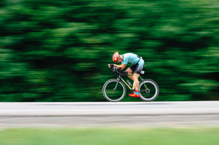 KHARKIV, UKRAINE - August 2, 2020: Triathon biking cyclist triathlete riding racing bike during ironman competition. Road cycling athlete in tri suit and helmet. Public events are allowed. Europe sport during CV pandemic.のeditorial素材