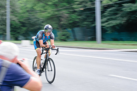 KHARKIV, UKRAINE - August 2, 2020: Triathon biking cyclist triathlete riding racing bike during ironman competition. Road cycling athlete in tri suit and helmet. Public events are allowed. Europe sport during CV pandemic.のeditorial素材