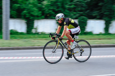 KHARKIV, UKRAINE - August 2, 2020: Triathon biking cyclist triathlete riding racing bike during ironman competition. Road cycling athlete in tri suit and helmet. Public events are allowed. Europe sport during CV pandemic.のeditorial素材