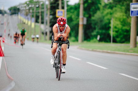 KHARKIV, UKRAINE - August 2, 2020: Triathon biking cyclist triathlete riding racing bike during ironman competition. Road cycling athlete in tri suit and helmet. Public events are allowed. Europe sport during CV pandemic.のeditorial素材