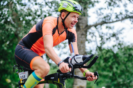 KHARKIV, UKRAINE - August 2, 2020: Triathon biking cyclist triathlete riding racing bike during ironman competition. Road cycling athlete in tri suit and helmet. Public events are allowed. Europe sport during CV pandemic.のeditorial素材