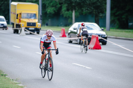 KHARKIV, UKRAINE - August 2, 2020: Triathon biking cyclist triathlete riding racing bike during ironman competition. Road cycling athlete in tri suit and helmet. Public events are allowed. Europe sport during CV pandemic.のeditorial素材