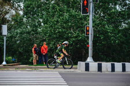 KHARKIV, UKRAINE - August 2, 2020: Triathon biking cyclist triathlete riding racing bike during ironman competition. Road cycling athlete in tri suit and helmet. Public events are allowed. Europe sport during CV pandemic.のeditorial素材
