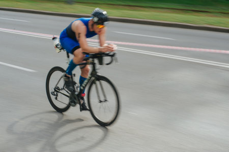 KHARKIV, UKRAINE - August 2, 2020: Triathon biking cyclist triathlete riding racing bike during ironman competition. Road cycling athlete in tri suit and helmet. Public events are allowed. Europe sport during CV pandemic.のeditorial素材