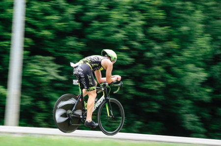 KHARKIV, UKRAINE - August 2, 2020: Triathon biking cyclist triathlete riding racing bike during ironman competition. Road cycling athlete in tri suit and helmet. Public events are allowed. Europe sport during CV pandemic.のeditorial素材