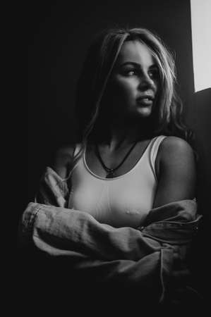 Silhouette of woman in jeans denim jacket and white sport bra. Rock star girl.の写真素材