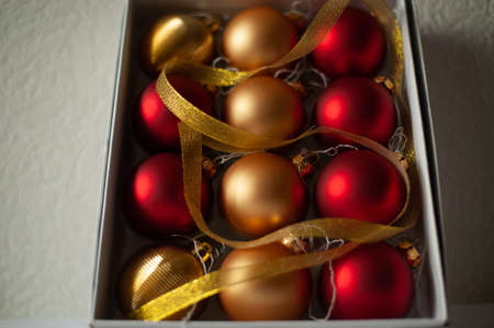 Red and gold christmas ball in white box. New Year and Christmas backgroundの写真素材