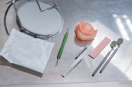 Set of dentures and dental tools. Close up Teeth and dental mirror. Diagnosis and copayment