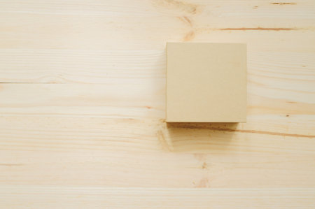 Paper box on the wood desk texture in daylight Office table in daylight