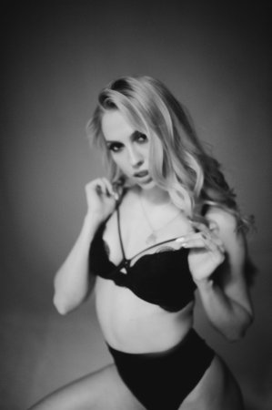 Blurred monochrome studio side portrait of young woman in black lingerie. Blur photoの写真素材