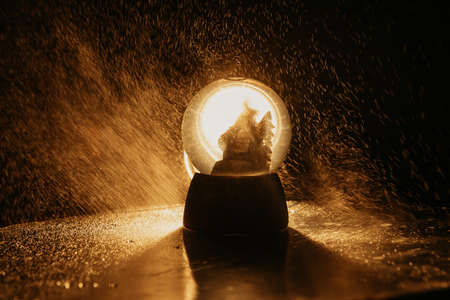 Snow Globe with drops. Table view and gold christmas items.の写真素材