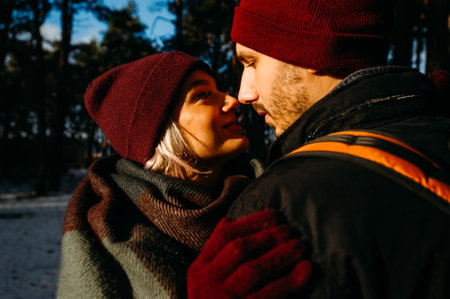 Vacation together. Young hipster couple. Woman kissing nose her boyfriend. Winter love story, a beautiful stylish young couple.の写真素材