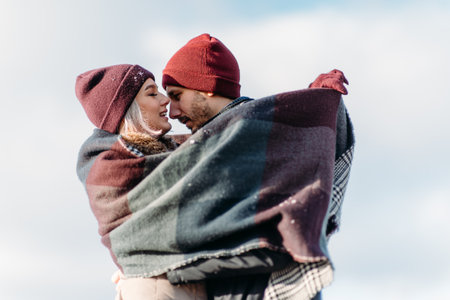 Vacation together. Young hipster couple. Woman kissing nose her boyfriend. Winter love story, a beautiful stylish young couple.の写真素材