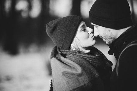 Vacation together. Young hipster couple. Woman kissing nose her boyfriend. Winter love story, a beautiful stylish young couple.の素材 [FY310161635716]