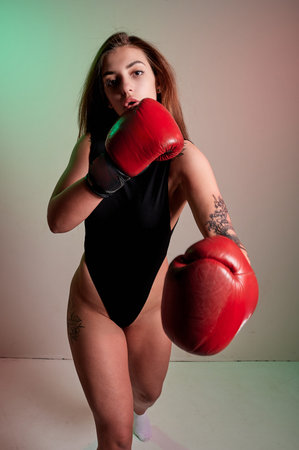 Beautiful woman with the red boxing gloves. Strength and motivation. Boxing and fitness style.