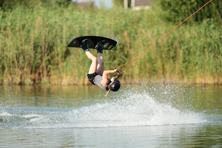 KHARKIV, UKRAINE - July 31, 2021: Championship of Ukraine. Wakeboarder showing of tricks and skills at wakeboarding event in Kharkiv.のeditorial素材