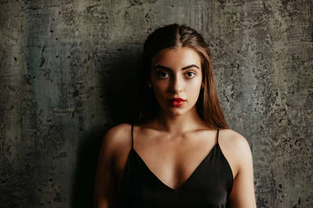 Portrait of brunette girl in a black dress. Individuality.の写真素材