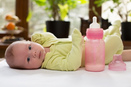 Newborn baby girl with a bottle of milk  The concept of food and parentingの写真素材