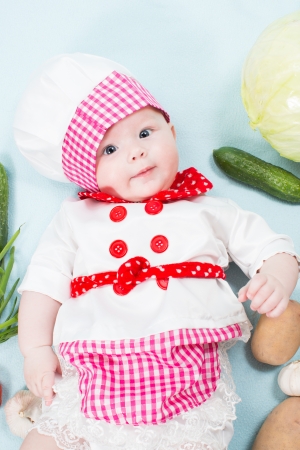 Baby girl  wearing a chef hat with vegetables  Use it for a child, healthy food conceptの写真素材