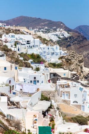 View of Fira town - Santorini island,Crete,Greece. White concrete staircases leading down to beautiful bay with clear blue sky and seaの写真素材