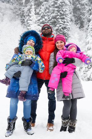 Happy Family with children in ski suit in snowy winter outdoors, Almaty, Kazakhstanの写真素材