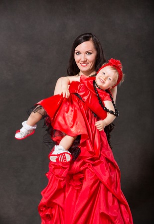 Happy mom and child girl hugging and laughing isolate on black background. The concept of cheerful childhood and family. Beautiful Mother and her babyの写真素材