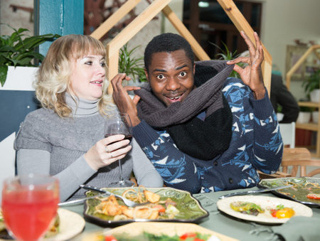 Portrait of happy couple black man and white woman with glass of wine at partyの写真素材