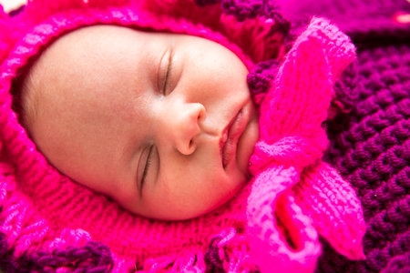 A cute newborn little baby girl sleeping. Use it for a child, parenting or love concept.