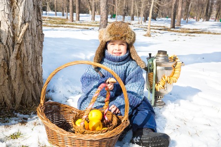 Little boy in a cap with earflaps plays winter park.  Russian style.の写真素材
