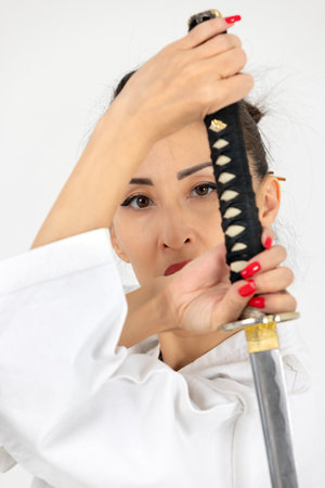 Aikido master woman in traditional samurai hakama kimono with black belt with sword, katana on white background. Healthy lifestyle and sports concept.の写真素材