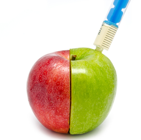 syringe injection in an apple isolated on white backgroundの写真素材