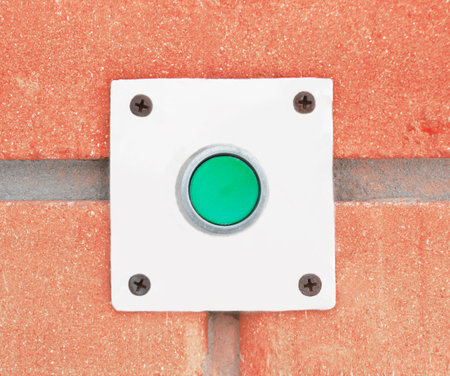 Close-up of pressing the button of a doorbell on a wall background