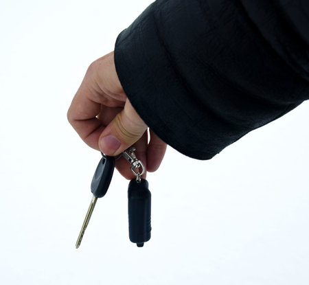 Male hand holding car key and alarm system charm against Christmas background
