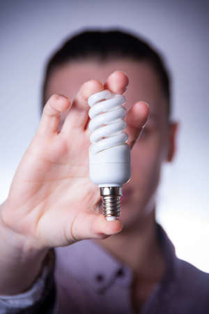 person holding energy saving lamp with vingetteの写真素材