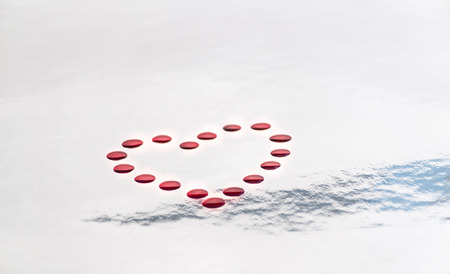 fragmented red heart with white background, pieces of red glass flakesの写真素材