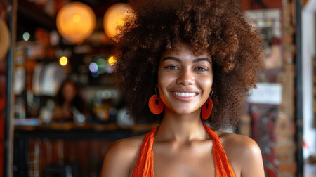 A woman with curly hair smiles brightly while wearing an orange dress in a dimly lit cafe.の素材