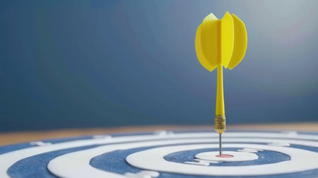 A yellow dart is perfectly centered in the bullseye of a dartboard.の素材