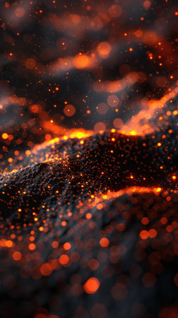 A close-up of orange and black bokeh lights with glowing particles.の素材