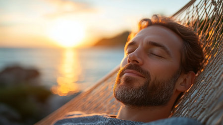 A man enjoys a peaceful moment in a hammock as the sun sets over the ocean, creating a tranquil atmosphere.の素材