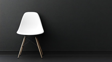 Simple white chair stands alone on a dark floor by a black wall in a contemporary space.の素材