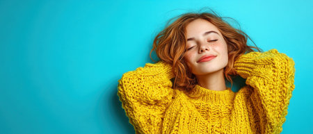 Woman enjoys a moment of peace, wearing a cozy yellow sweater, against a vibrant blue backdrop.の素材