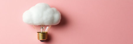A light bulb designed to resemble a fluffy cloud is mounted on a pink background, showing creativity.の素材