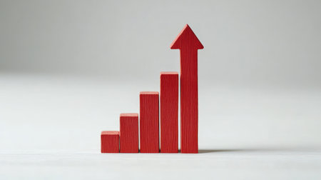 Red wooden blocks arranged in ascending order with an arrow demonstrating increasing business growth.の素材