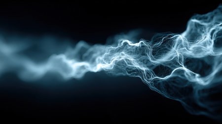 Delicate wisps of white and blue smoke twist gracefully through a dark setting creating a mesmerizing spectacle.の素材