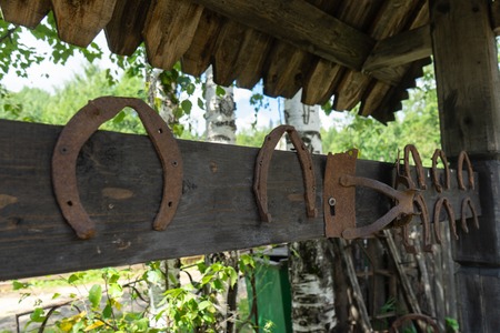 Old horseshoes fastened with screws to a wooden surface.の写真素材